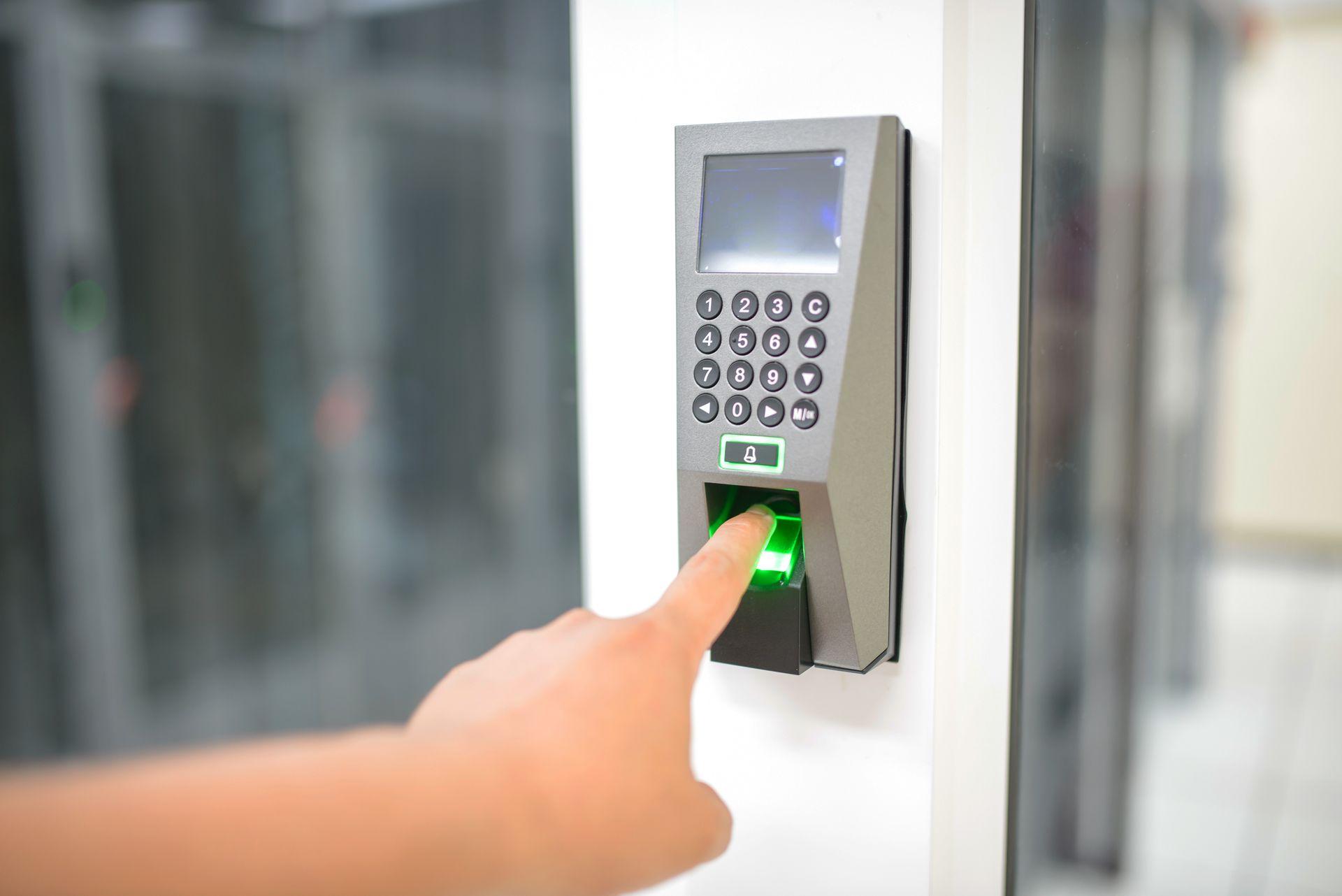 Dedo encostado em leitor biométrico de impressão digital na parede