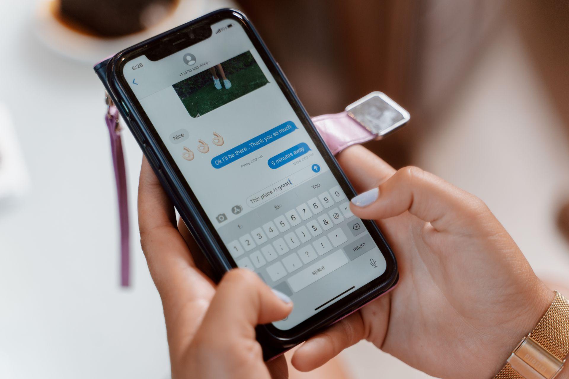 Mãos segurando um celular com aplicativo de mensagens aberto